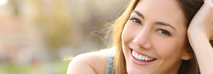 Smiling lady outdoors, representing health and well-being.